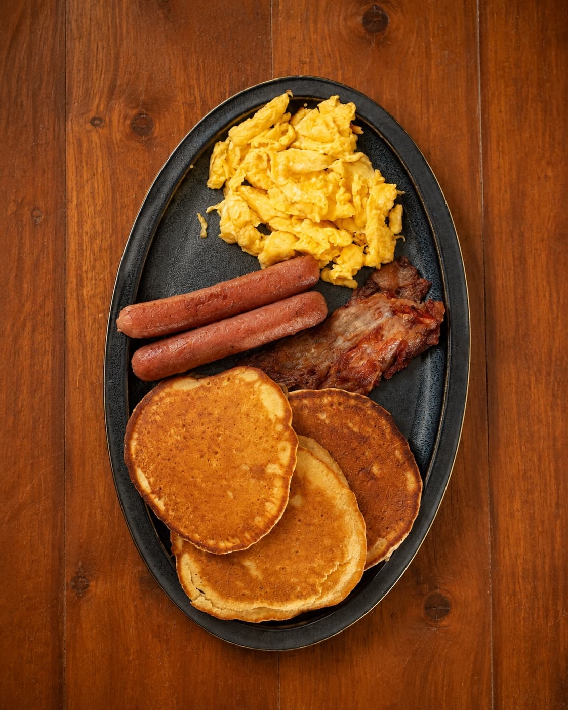 Desayuno Americano con huevo, salchichas, tocino y hot cakes