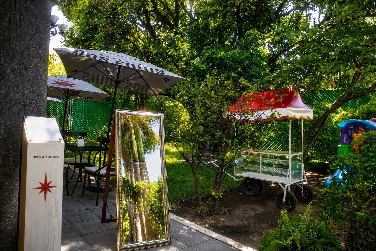 Terraza de Shukran con espejo, sombrillas y vegetación