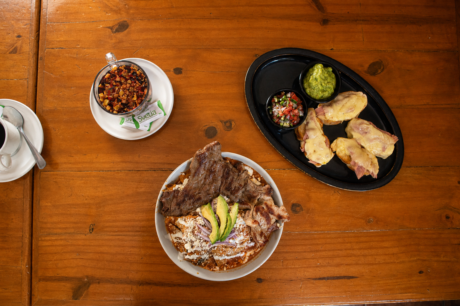 Chilaquiles, molletes, café y tisana servidos en la mesa de Shukran
